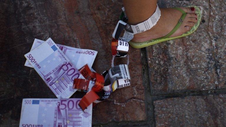 A demonstrator hangs fake Euro notes on her leg during a protest against Spain's bailout in Malaga June 10 2012.