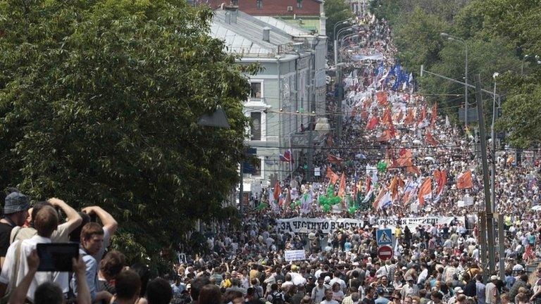 Participants march with flags and placards during an anti-government protest in Moscow