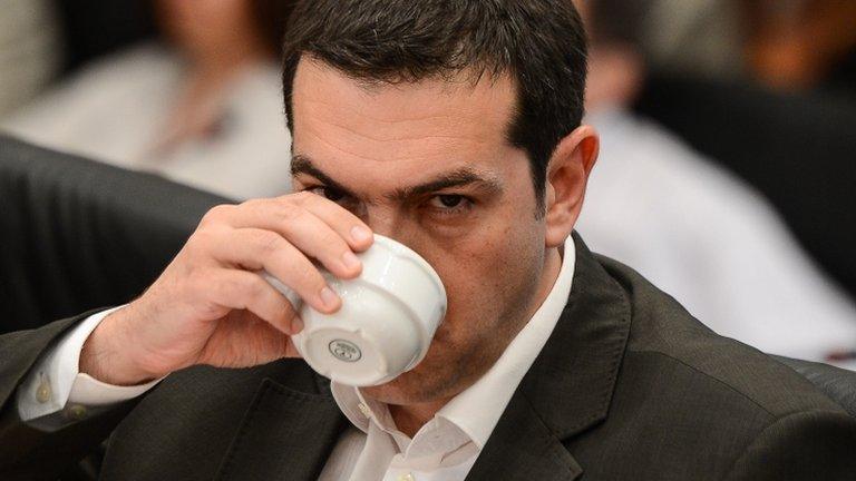 Alexis Tsipras takes a drink during a news conference in Athens, 12 June