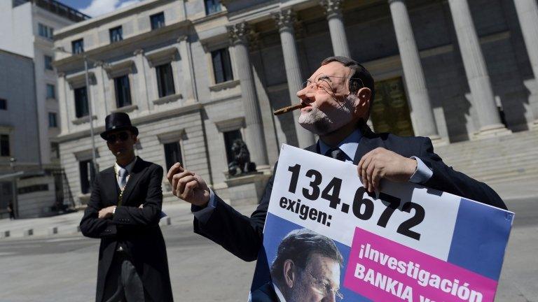 Activists in Madrid stage a satirical performance depicting Prime Minister Mariano Rajoy (R) and bailed-out bankers (L)