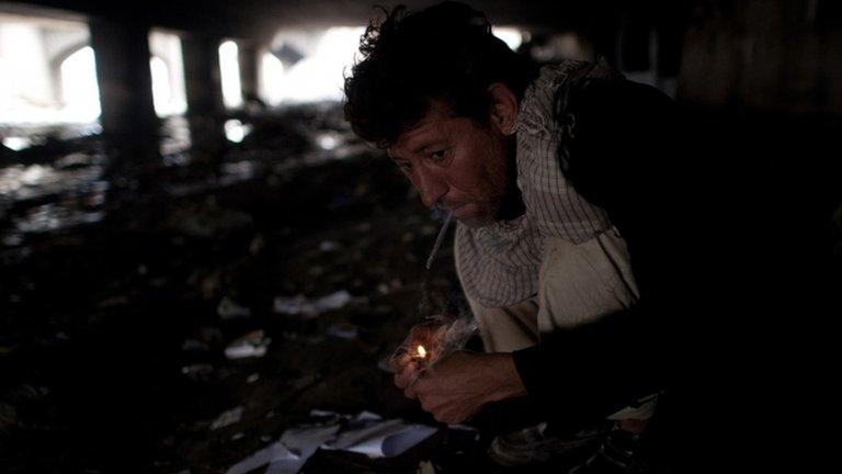 A man smokes heroin under a bridge in Kabul, Afghanistan 25 April 2012