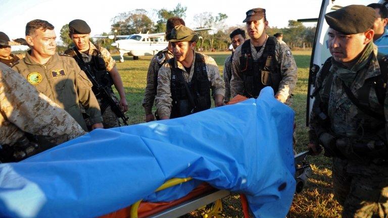 The body of a police officer killed in clashes with landless farmers is taken to Asuncion