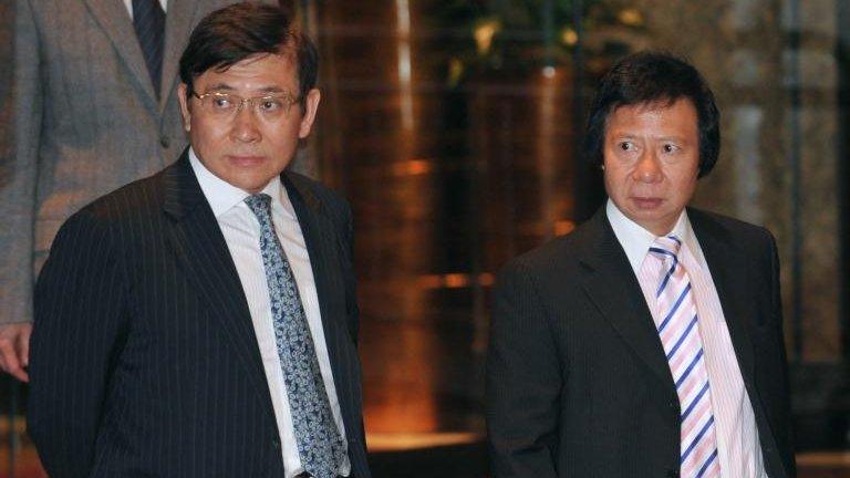 In this file picture taken on 3 April, 2012, Raymond Kwok (L) and Thomas Kwok (R) walk towards a press conference in Hong Kong