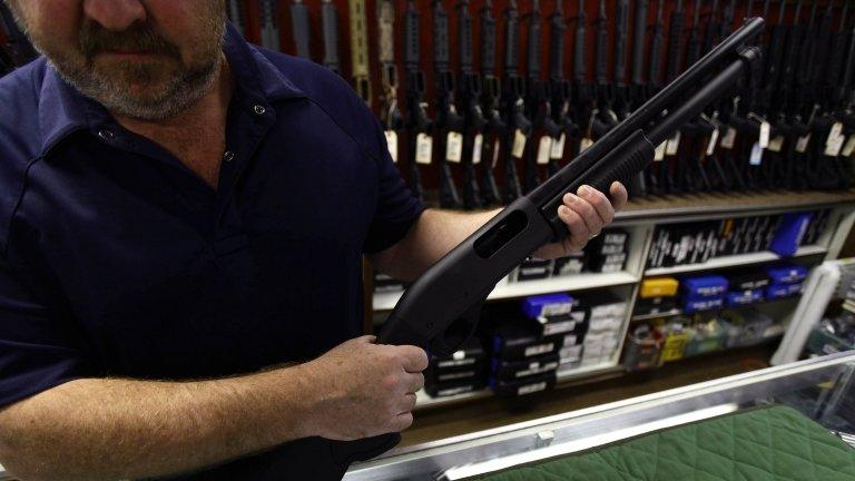 A man displays a rifle in a gun shop in Aurora, Colorado (22 July 2012)