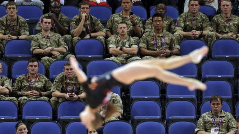 British soldiers watch gymnast Simona Castro Lazo from Chile perform during the Artistic Gymnastics women's qualification at the 2012 Summer Olympics