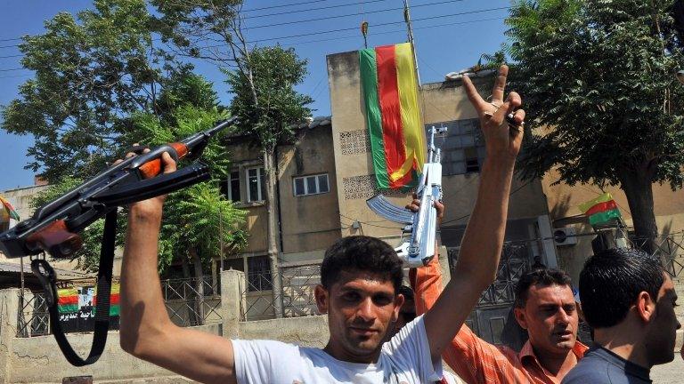 Syrian Kurds hold their rifles in Jinderes, near the northern Syrian city of Aleppo, 22 July 2012