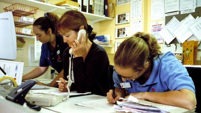 Nurses and health worker at hospital ward desk (model release)