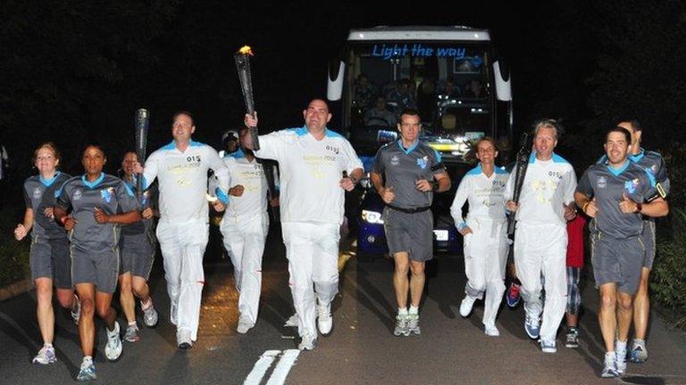 A torchbearing team carries the Paralympic Flame on the Torch Relay leg between Aylesbury and Weston Turville