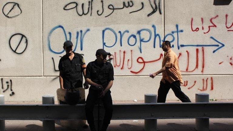 Egyptian soldiers stand guard in front of the US embassy, defaced by people protesting against an allegedly offensive film about the Prophet Muhammad, in Cairo, Egypt, on Wednesday