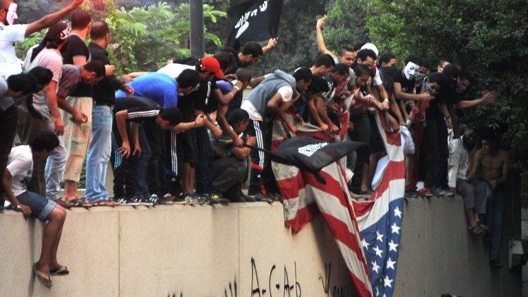 Egyptian protesters tear down the US flag at the US embassy in Cairo