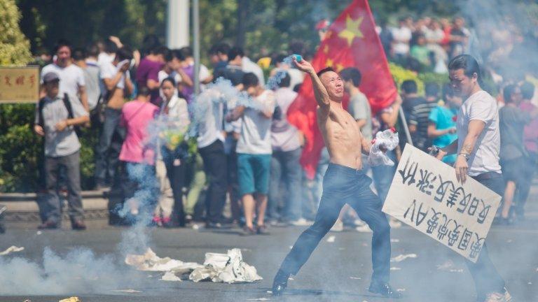 A Chinese protester throws a gas canister during an anti-Japan rally in Shenzhen, southern China. Photo: 16 September 2012