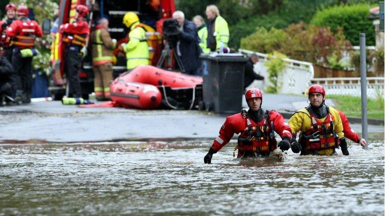 Rescue workers wade through flood water in Morpeth