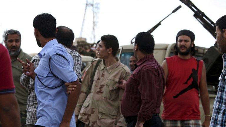 Members of the Rafallah Sahati Islamic Militia Brigades argue with a Libyan policemen