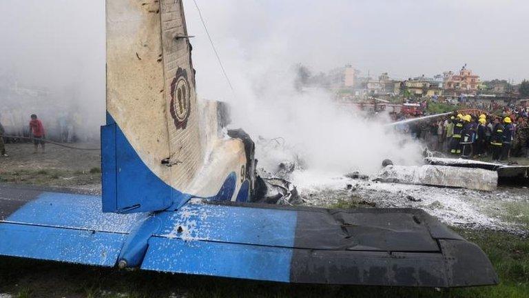 Firefighters put out flames on tail wreckage