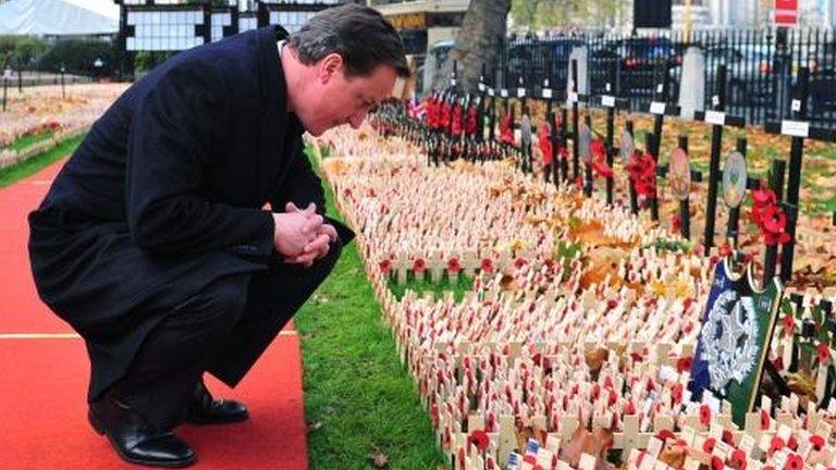 David Cameron pictured in 2009 looking at commemorative crosses