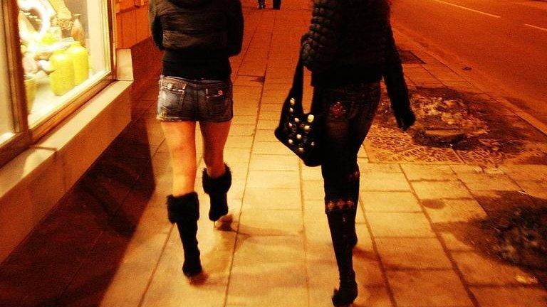 Women walking down street at night