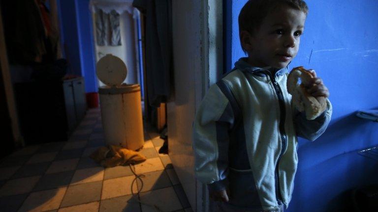 A Roma (Gypsy) boy eats a piece of bread in his flat in Miskolc, Hungary, 17 October