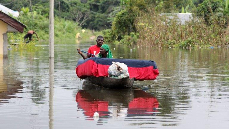 A man and his wife paddle a canoe with their belongings after flooding in the Amassoma community in Bayelsa state October 5, 2012.