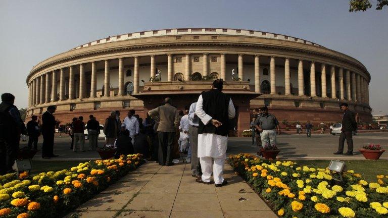 Indian lawmakers stand outside the Indian Parliament on the opening day of the winter session in New Delhi, India, Thursday, Nov. 22, 2012.