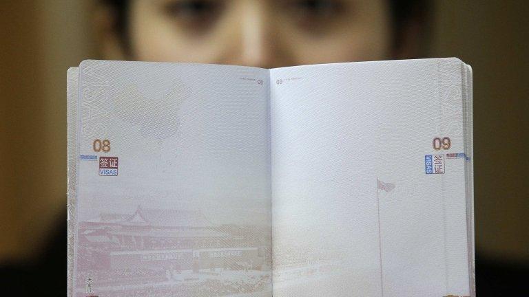 A woman holding up the new Chinese passport with a controversial map