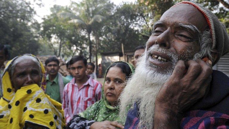 A father mourns as he looks for the body of his son outside the Tazreen factory