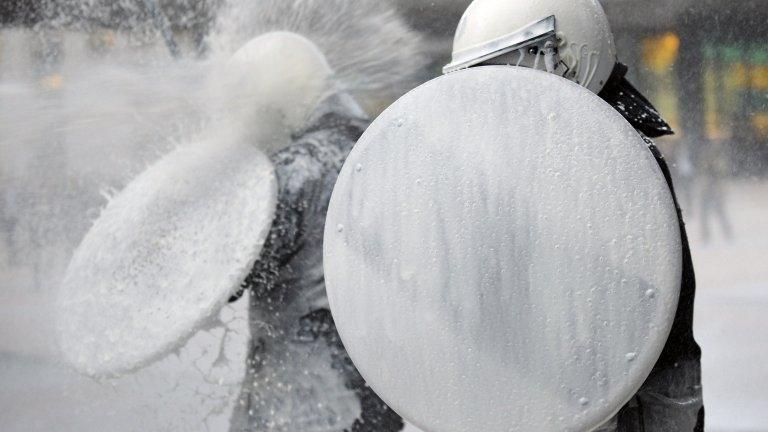 Police are hosed with fresh milk outside the European Parliament in Brussels, 26 November