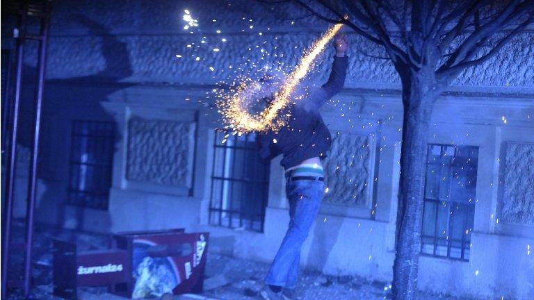 A protester throws a firework during demonstrations in Maribor, Slovenia, 3 December 2012