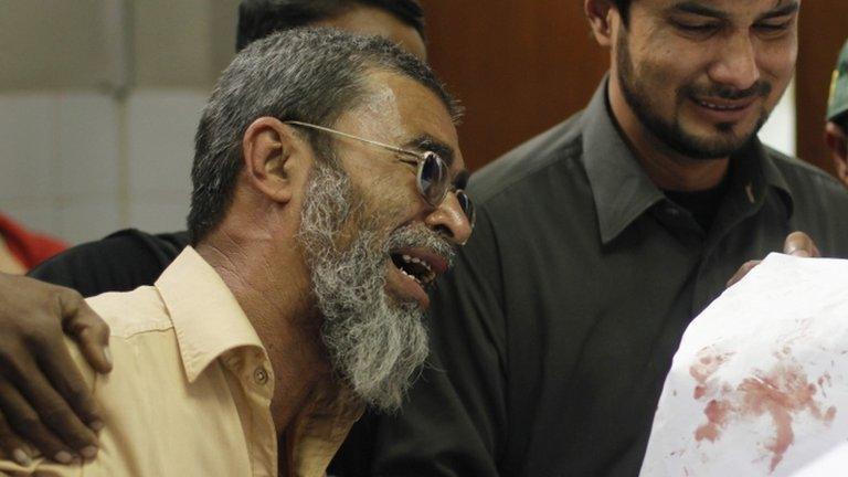 Amtiaz Khan (left), brother of Nasima Bibi, a female worker of an anti-polio drive campaign who was shot by gunmen, mourns her death at a hospital morgue in Karachi December 18, 2012.