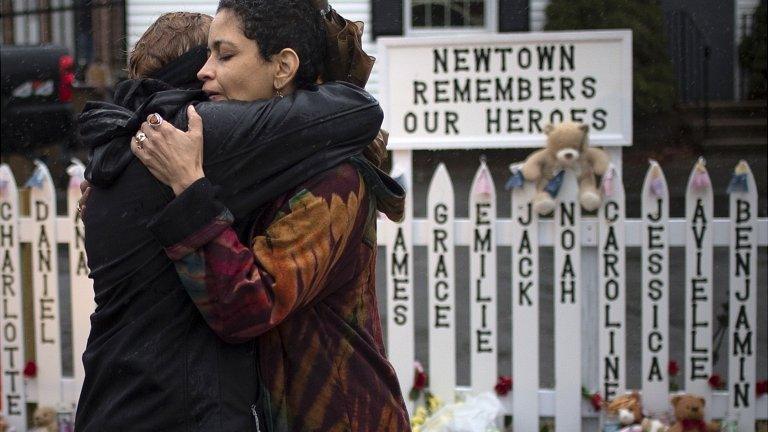 Women embrace after a moment's silence in Newtown, 21 Dec 2012