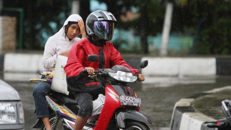 An Acehnese woman rides on the back side of a motorcycle in Banda Aceh, 2 January 2013.