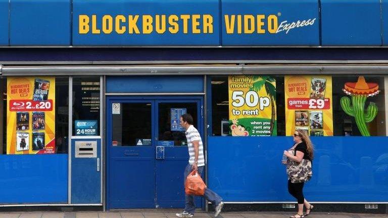 People walk past Blockbusters store (file photo 2010)