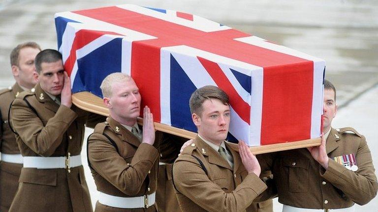 Union flag-draped coffin carried off plane