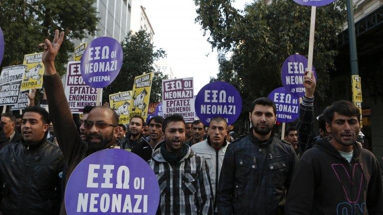 Immigrants hold banners reading "Neonazis Out" during an anti-racism rally in Athens, 19 January 2013