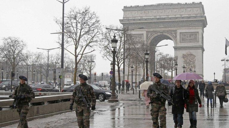 French soldiers patrol down the Champs Elysees avenue near the Arc de Triomphe in Paris