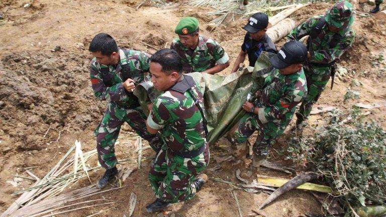 Indonesian soldiers evacuate a dead body, the victim of a recent landslide that hit Nagari Sungai Batang village in Agam