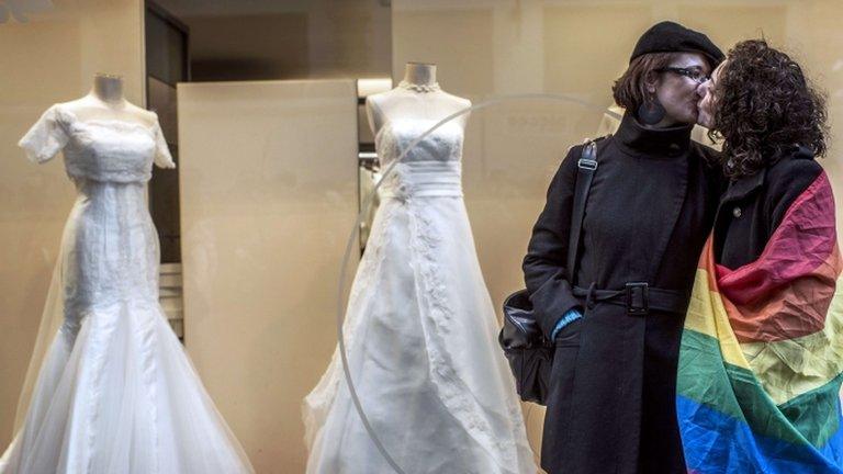 Two women kiss outside a bridal shop in Lyon, France, 26 January