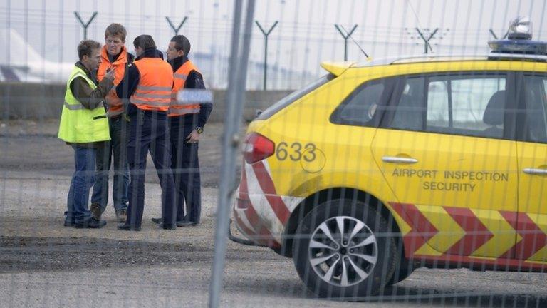 Airport security guards and officials stand near an entrance to the runway at Zaventem international airport near Brussels on Tuesday following the diamond theft