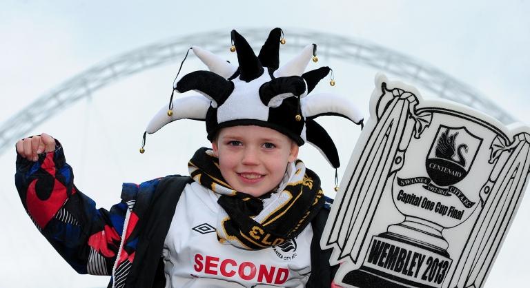 Swansea City fan Cam Warren, seven, shows his support outside Wembley Stadium before the Capital One Cup Final match at Wembley