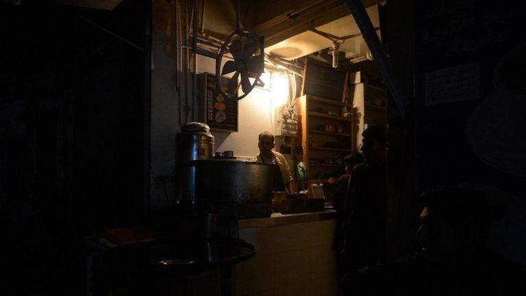 A Pakistani man preparing tea at his restaurant during a nationwide power blackout in Karachi, 24 February 2013