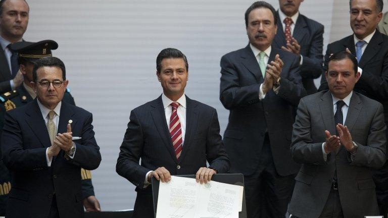 Mexico's president, Enrique Pena Nieto, shows signed education reform document