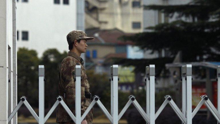 A Chinese People's Liberation Army soldier stands guard in front of "Unit 61398", a secretive Chinese military unit, in the outskirts of Shanghai, February 19, 2013