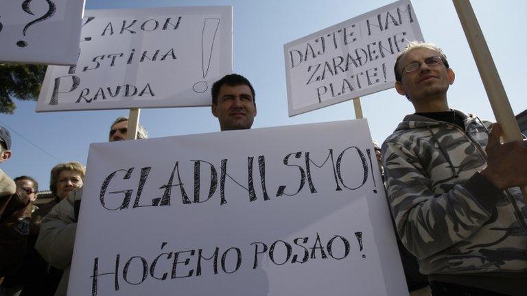 People hold up banners saying "we are hungry", "we want jobs" and "we want our salaries" in front of a municipality building in Drvar, Bosnia-Hercegovina (4 March 2013)