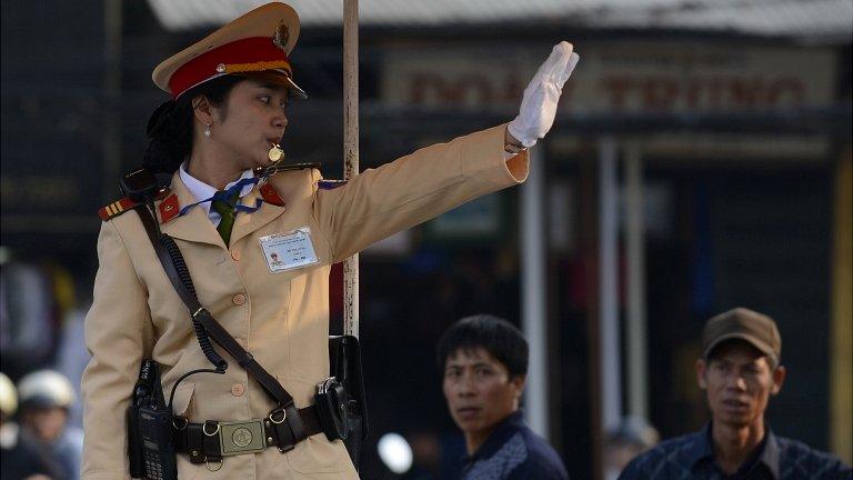 A Vietnamese police woman directs traffic in Hanoi