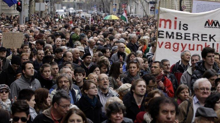 Hungarian NGOs hold up a banner (constitution democracy rule of law) as they protest at changes to the new constitution in Budapest on March 9, 2013.