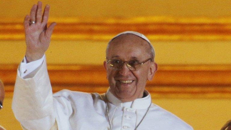 Pope Francis waves to the crowd from the central balcony of St. Peter"s Basilica at the Vatican