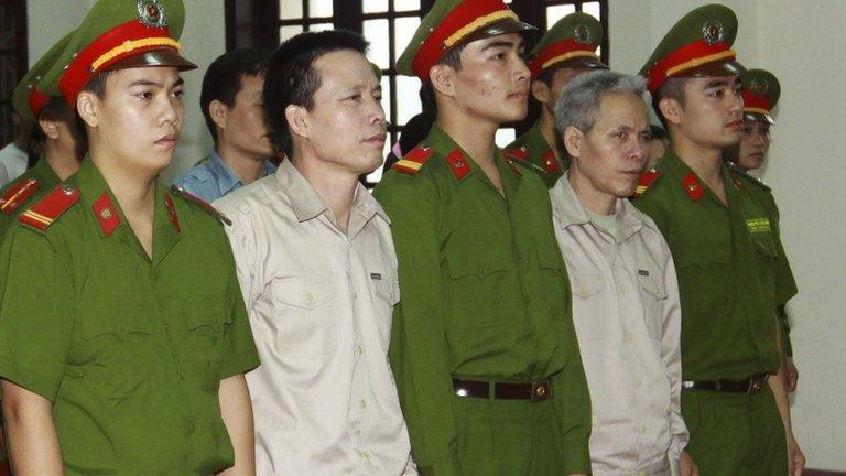 In this April 2, 2013 file photo, Doan Van Vuon, second from left and his brother Doan Van Sinh, fourth from left, stand trial at the court in the northern city of Haiphong, Vietnam.