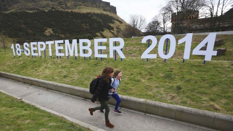 Children running alongside sign showing referendum date