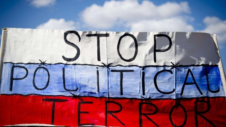 A Russian flag held by protesters outside a trade fair in Hanover, 7 April 2013