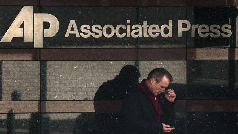 Man looks at his phone outside the offices of the Associated Press in Manhattan, New York (13 May 2013)