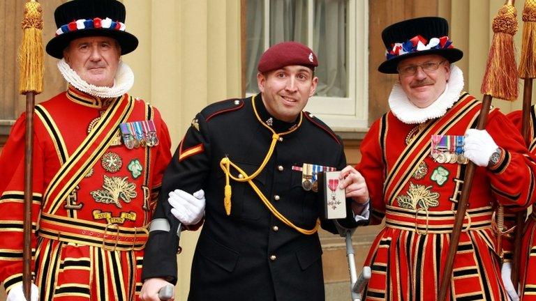 L/Bombardier Parkinson with members of the Yeoman of the Guard after receiving his MBE medal